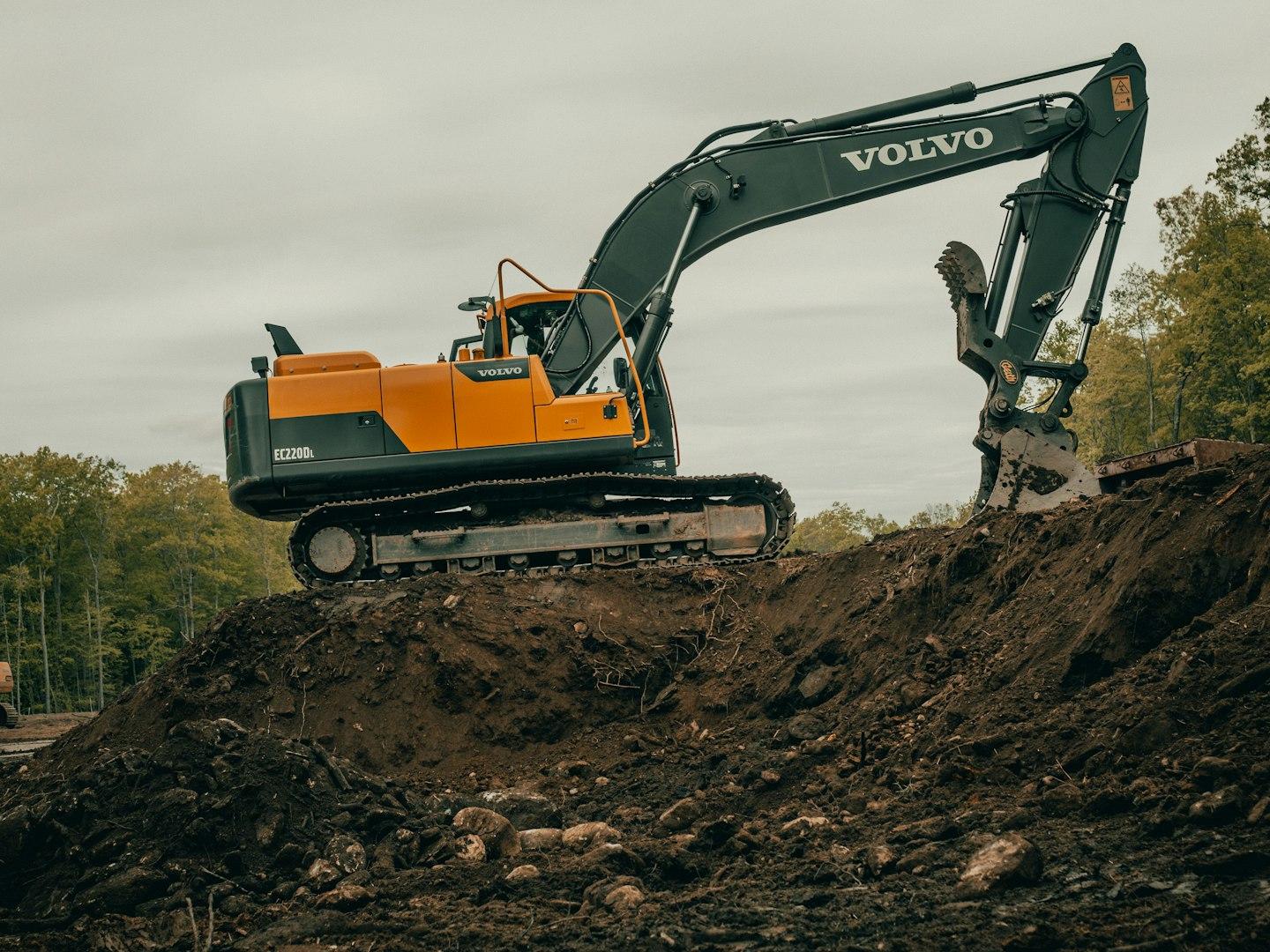 orange and white excavator on brown ground during daytime